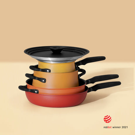 The Meyer pan set stacked, displaying the colour gradiant from red through orange to yellow. 